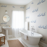 Bathroom with white freestanding bathtub, sink, and decorative wall patterns.
