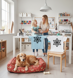 mother and child stenciling snowflakes on tshirts in a craft room