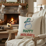 Decorative pillow with a snowman and 'Happy Holidays' text in a cozy living room with a fireplace.