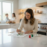 Woman painting at a kitchen counter with children in the background