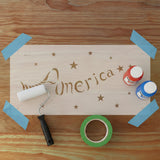 Wooden sign with 'America' and star designs on a wooden surface