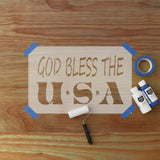 Wooden sign with 'GOD BLESS THE U.S.A.' text on a wooden surface