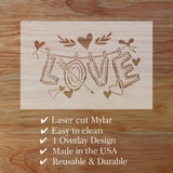 Laser cut Mylar design with 'LOVE' and hearts on a wooden surface