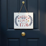 Front door sign with 'AMERICA EST. 1776' text surrounded by stars and leaves on a white background. 