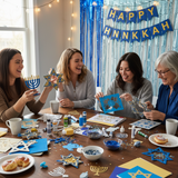 Four women celebrating Hannukah with decorations and food at a table.