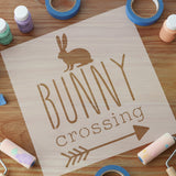 Bunny Crossing stencil with acrylic paints and rollers surrounding it.