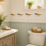 Bathroom with wooden vanity, white toilet, and decorative wall art.