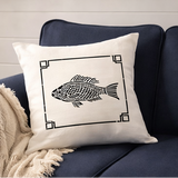 Decorative pillow with fish design on a navy blue couch