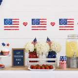 Decorated table with American flags, lemonade, and small American flags on a white wall.