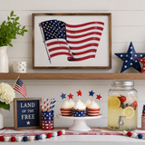 Decorative setup with American flag, cupcakes, and lemonade on a table.