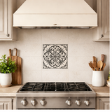 Decorative tile on a kitchen wall with stove and wooden utensils in the foreground

