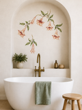 Bathroom with a freestanding bathtub, floral wall decal, and decorative items.