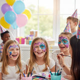 Children with face paint at a birthday party, surrounded by balloons and party hats.