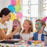 Children with face paint at a birthday party, surrounded by balloons and streamers.