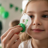 Person applying the St. Patrick's Day Face Painting stencil onto a child's face at a St. Patrick's Day Party.