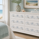 White dresser with decorative shell patterns in a room with beach-themed decor.