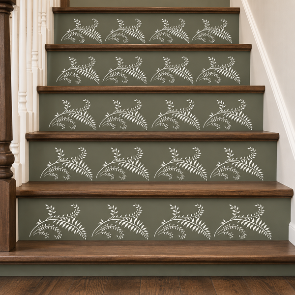 A staircase with dark olive green risers decorated with a repeating white leafy vine pattern, bordered by medium brown wooden steps.