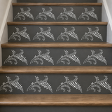 A set of dark gray stair risers decorated with a repeating white stenciled fern pattern, paired with natural wood treads.