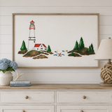 Framed artwork of a lighthouse on a wall above a dresser with decor items.