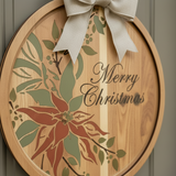 Wooden round decoration with floral design and 'Merry Christmas' text, featuring a bow.