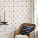 Nautical-themed room with anchor wallpaper, wicker chair, and decorative items.