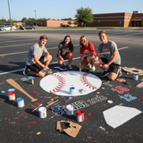 Four teenagers painting a baseball-themed design on a parking lot, with 'Senior 2023' text.