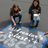 Text 'This Seniors Last Disco' stenciled on pavement with matching stencil.