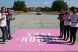 Text 'The Last Rodeo' painted onto a high school parking space