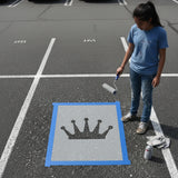 High School student about to stencil a crown design using a parking space stencil