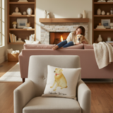 Woman sitting on a couch with a dog in a cozy living room, featuring a cushion with a Labrador Retriever design.